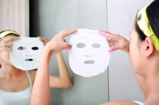 Young woman applying cosmetic facial mask in the bathroom. Young woman applying cosmetic facial mask in the bathroom.