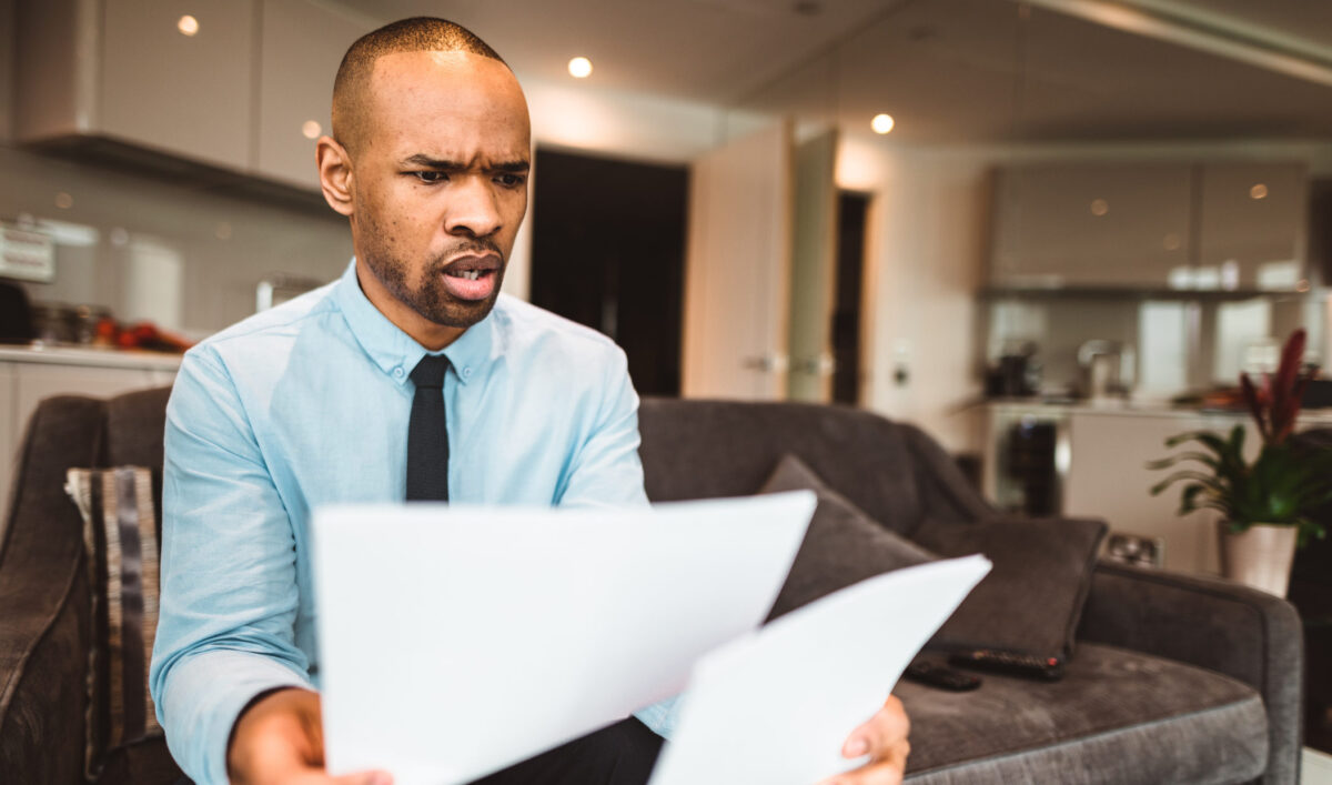 businessman reading rading the bills at home